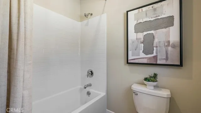a white toilet sitting next to a bath tub shower