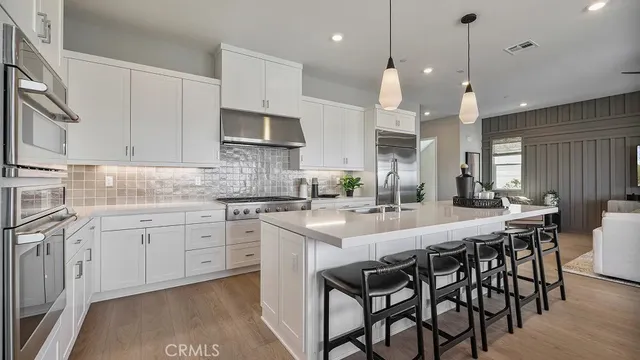 a kitchen with kitchen island granite countertop a table chairs sink and cabinets