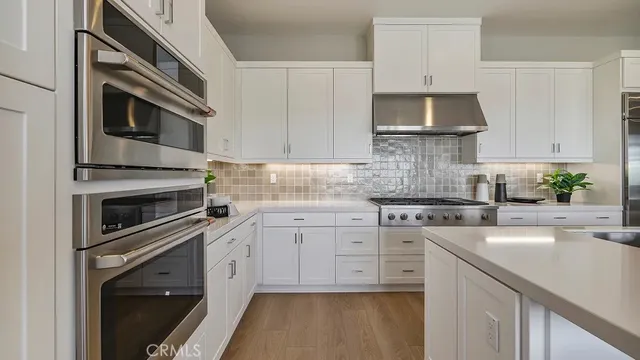 a kitchen with cabinets stainless steel appliances and sink