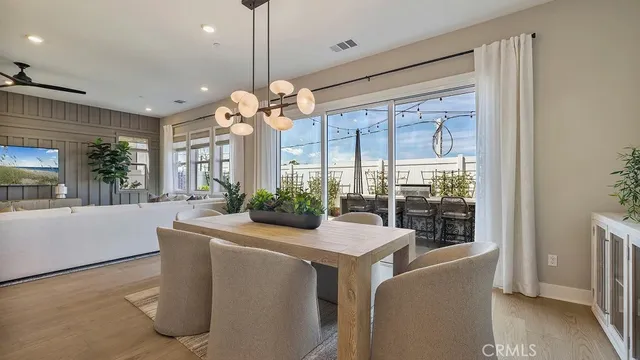 a room with chandelier fan and wooden floor