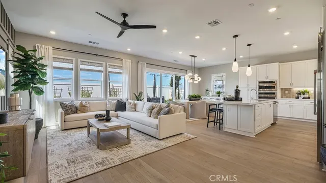 a living room with furniture kitchen and a large window