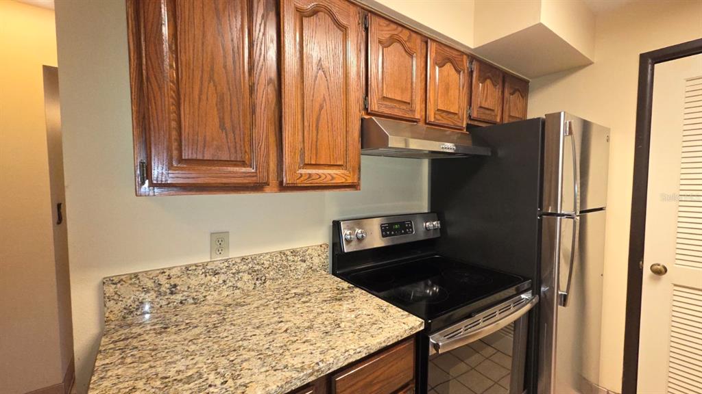 454 Cottage Circle, Unit 454 River Ranch, FL 33867 - Photo 10 of 27 a kitchen with stainless steel appliances granite countertop a refrigerator a stove and a sink
