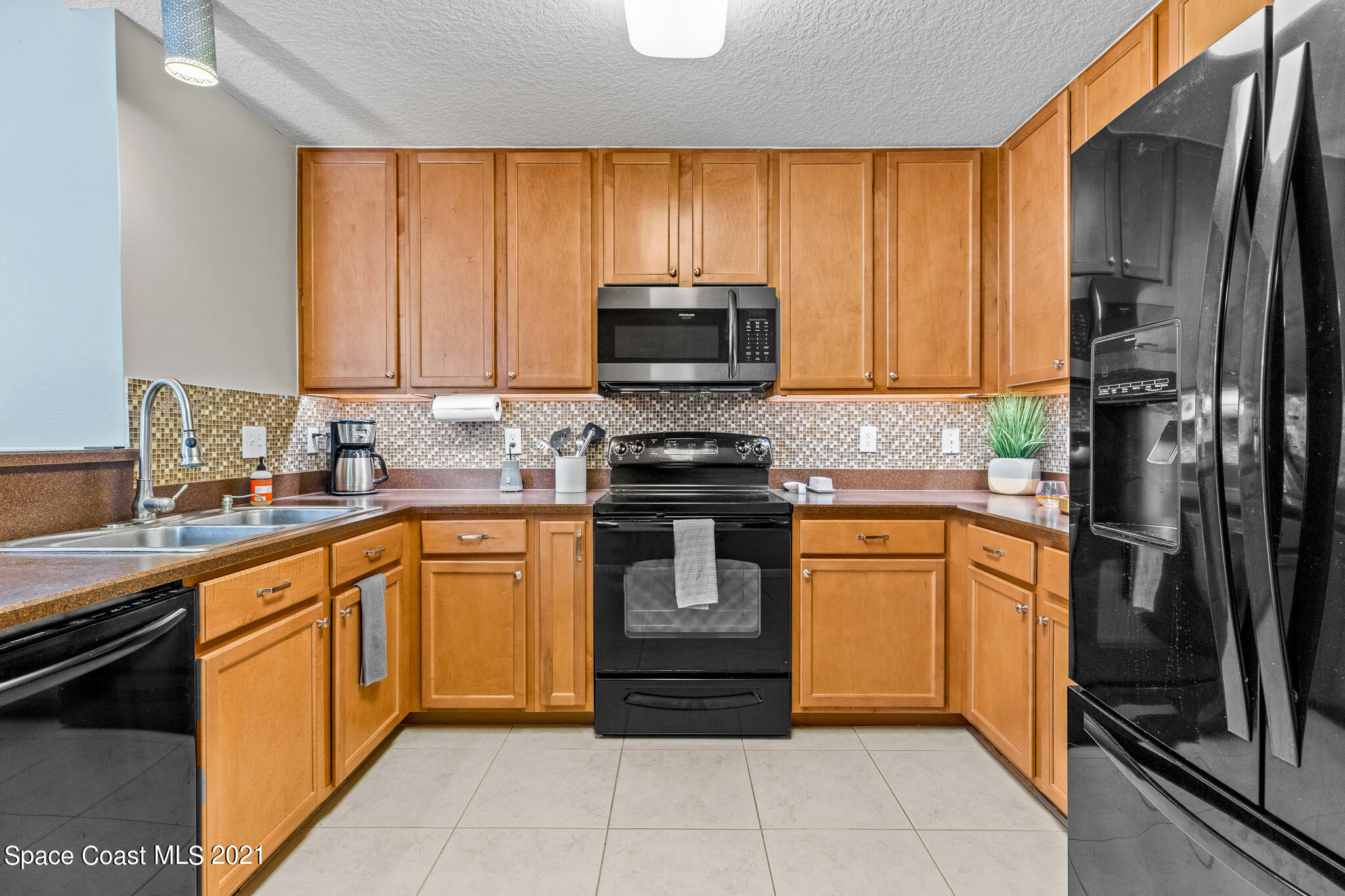 4056 Meander Place, Unit 201 Rockledge, FL 32955 - Photo 11 of 27 a kitchen with stainless steel appliances granite countertop a stove a sink and a refrigerator