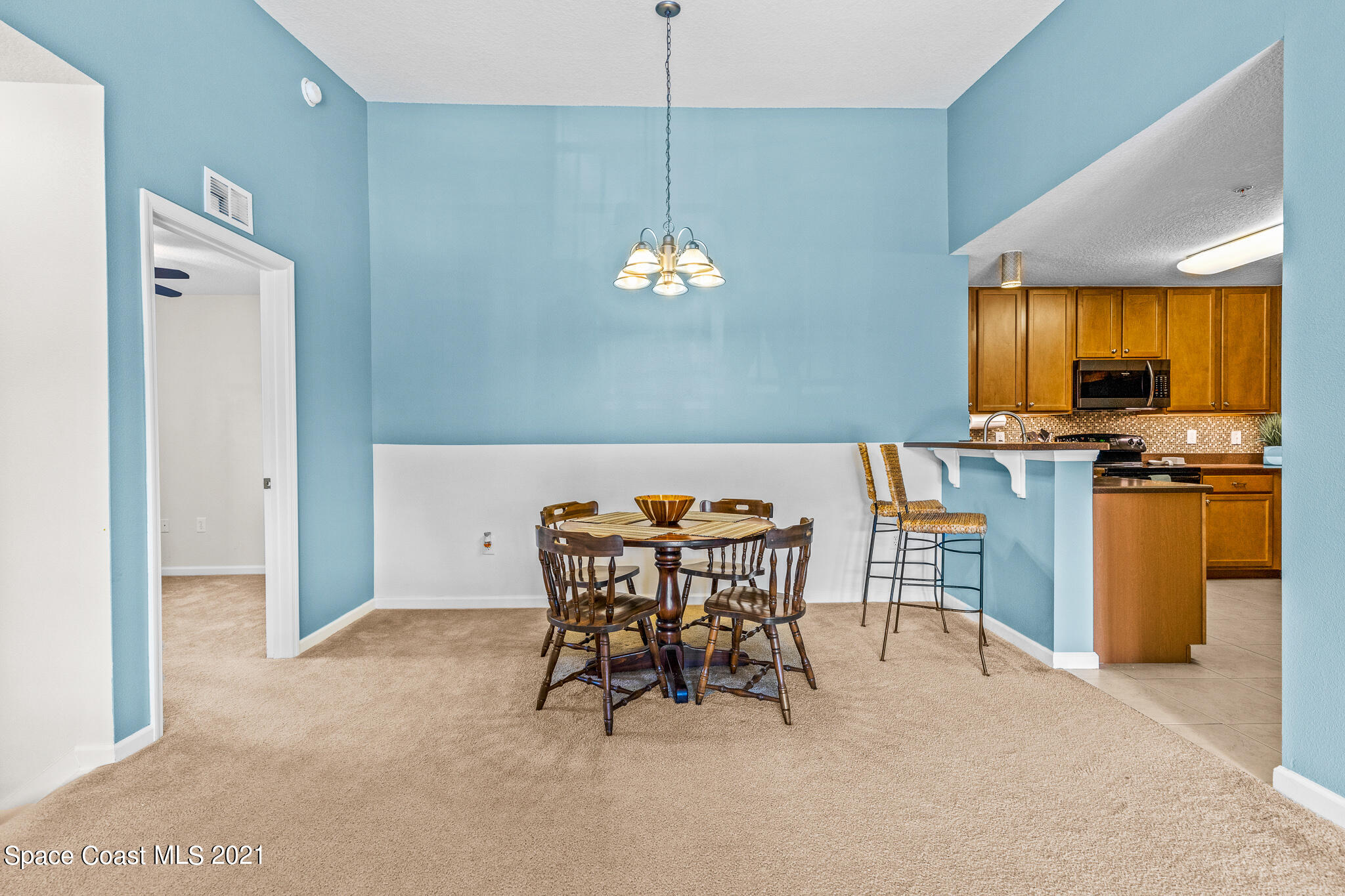 4056 Meander Place, Unit 201 Rockledge, FL 32955 - Photo 13 of 27 a dining room with furniture and chandelier