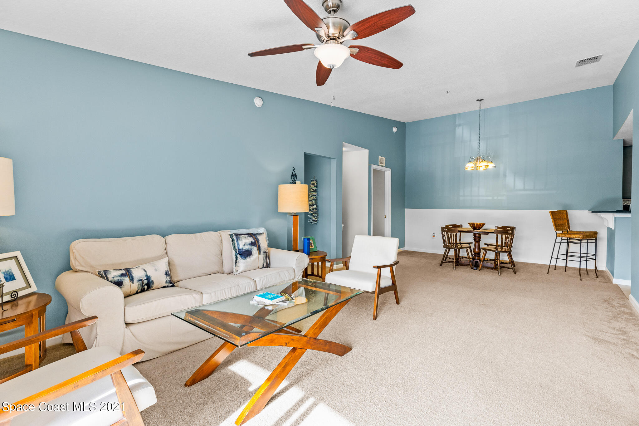 4056 Meander Place, Unit 201 Rockledge, FL 32955 - Photo 16 of 27 a living room with furniture and a chandelier