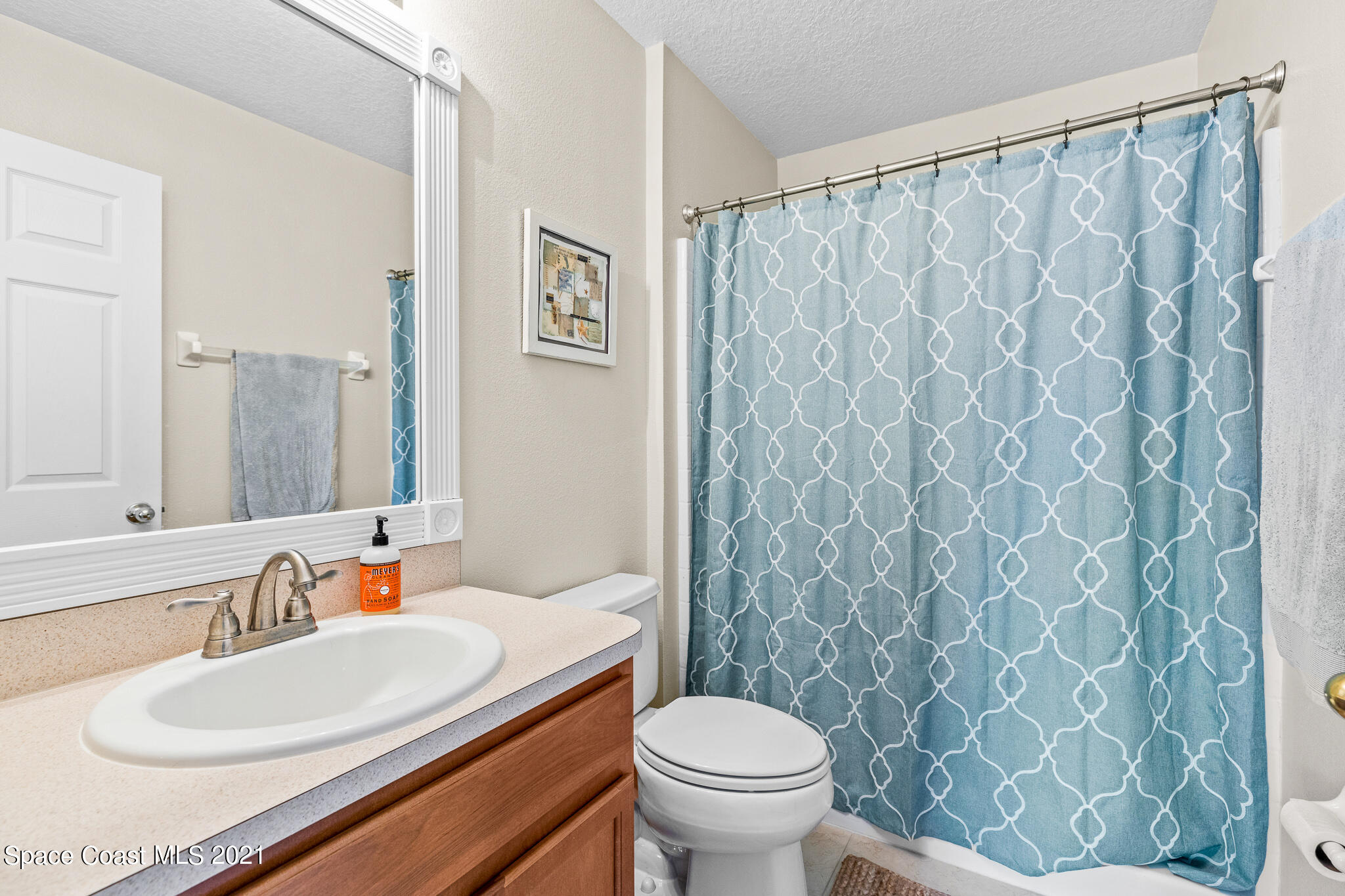 4056 Meander Place, Unit 201 Rockledge, FL 32955 - Photo 19 of 27 a bathroom with a sink a toilet and a mirror