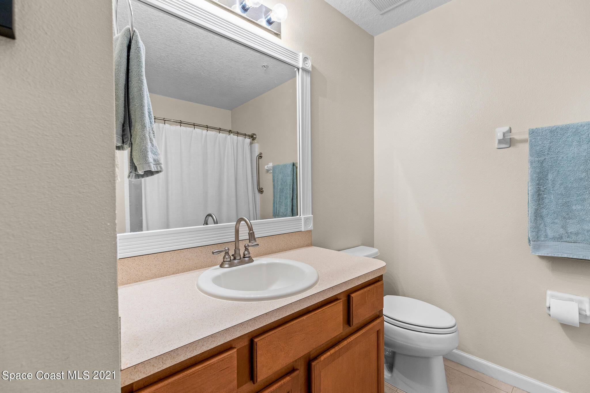 4056 Meander Place, Unit 201 Rockledge, FL 32955 - Photo 8 of 27 a bathroom with a sink toilet and mirror