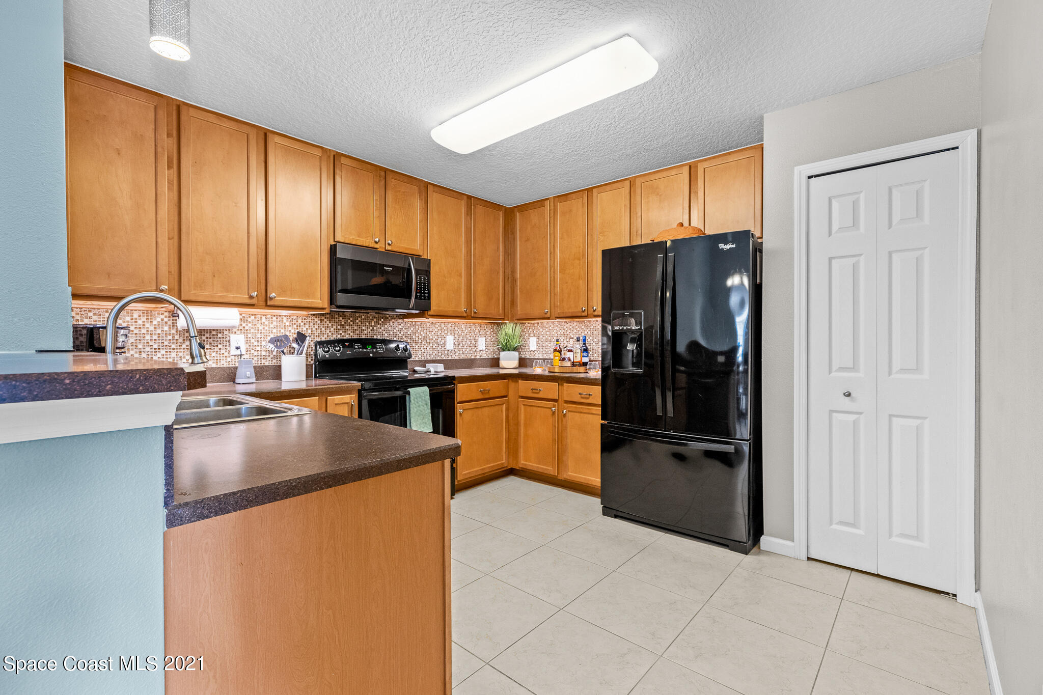4056 Meander Place, Unit 201 Rockledge, FL 32955 - Photo 10 of 27 a kitchen with granite countertop stainless steel appliances a refrigerator and a sink