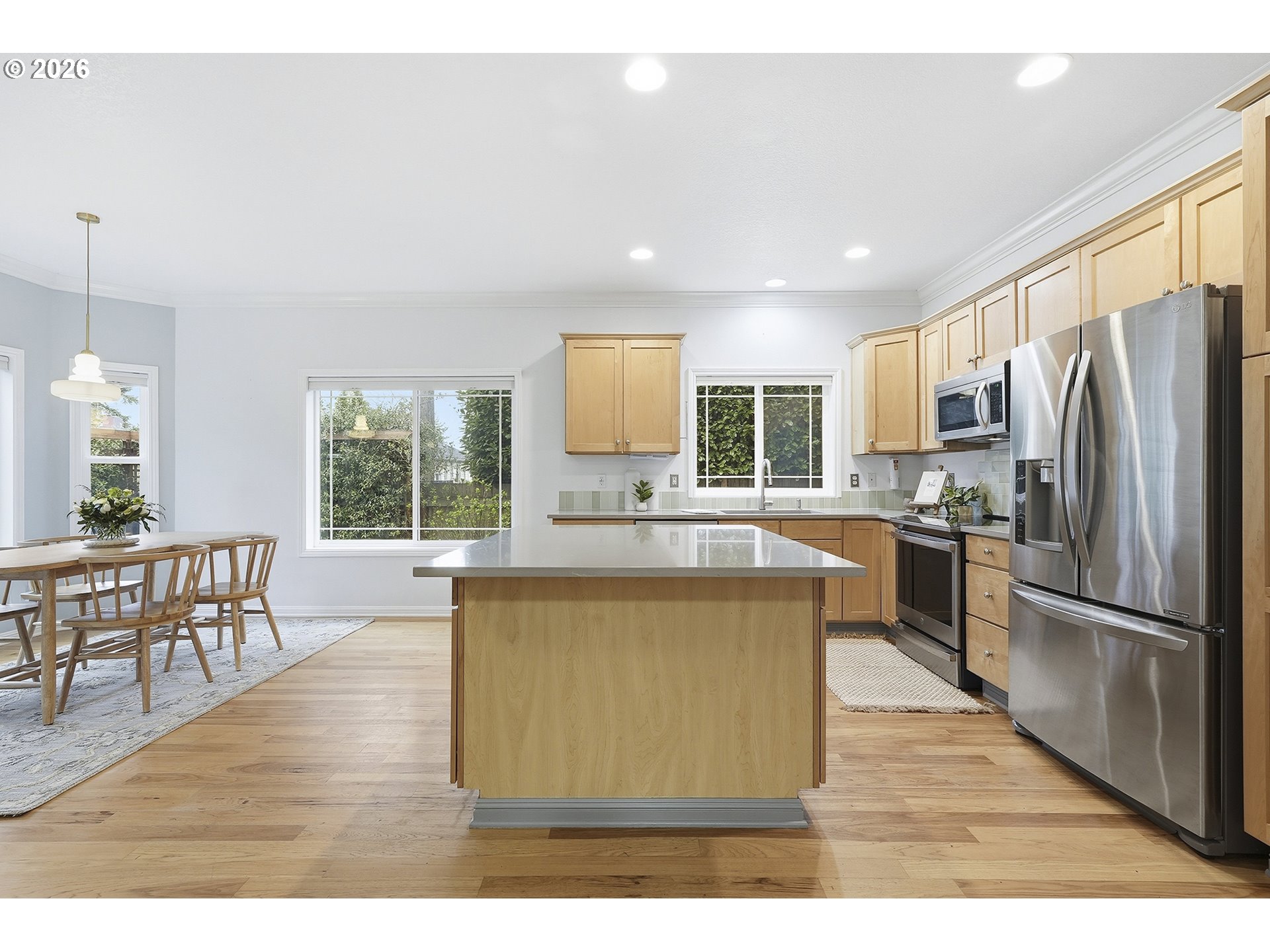 3307 North Terry Street Portland, OR 97217 - Photo 8 of 37 a large kitchen with stainless steel appliances granite countertop a refrigerator a stove a sink a dining table and chairs with wooden floor