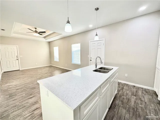 a hallway with a sink a mirror and wooden floor