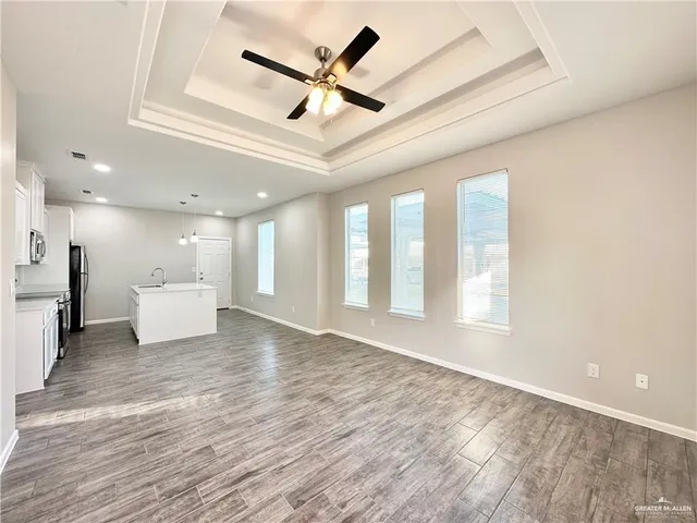 a view of an empty room with a window and a ceiling fan