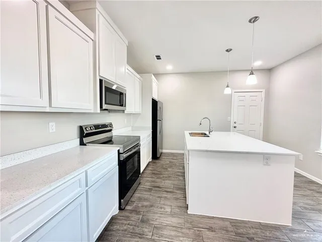 a kitchen with stainless steel appliances a microwave sink and cabinets