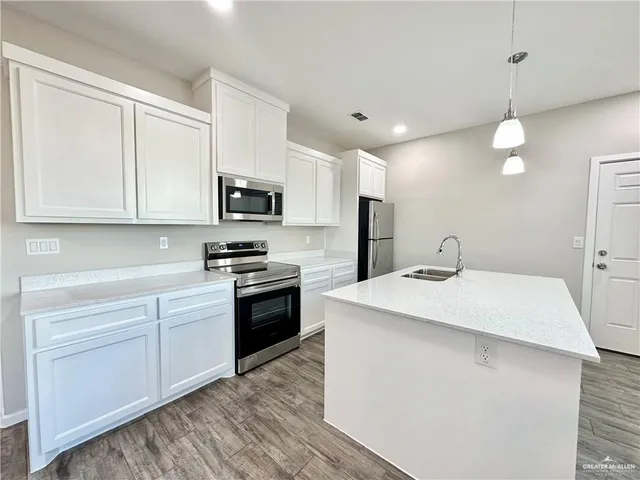 a kitchen with kitchen island a sink stainless steel appliances and cabinets