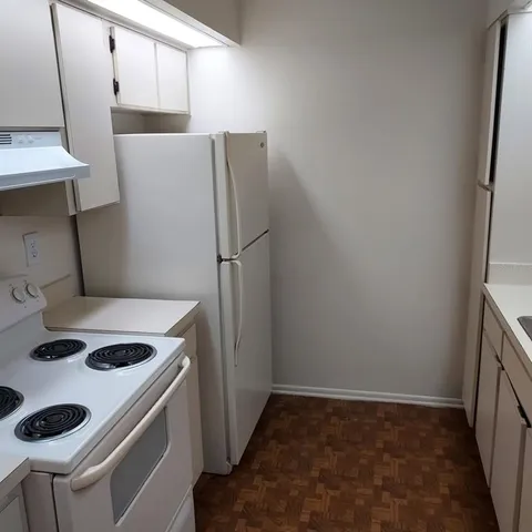 a kitchen with a refrigerator and a stove