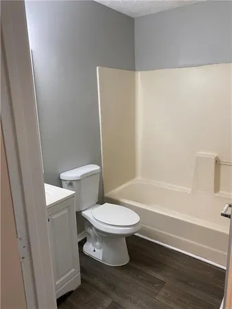 a white toilet sitting next to a bath tub