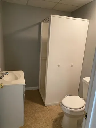 a white toilet sitting next to a shower