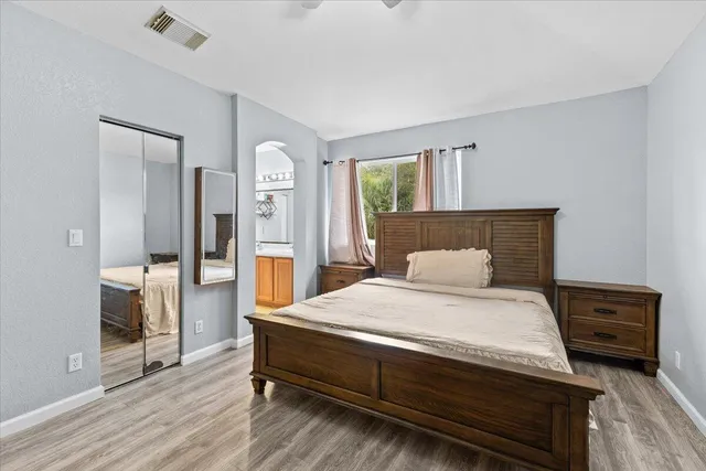 a bedroom with a bed mirror and a window