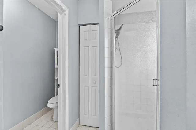 a bathroom with a granite countertop shower and a toilet