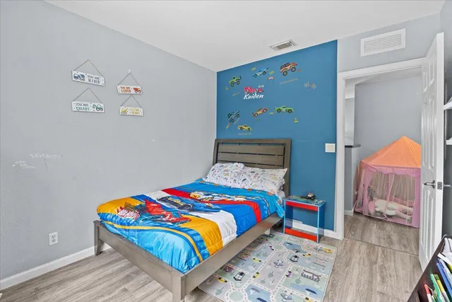 a bedroom with a bed and wooden floor