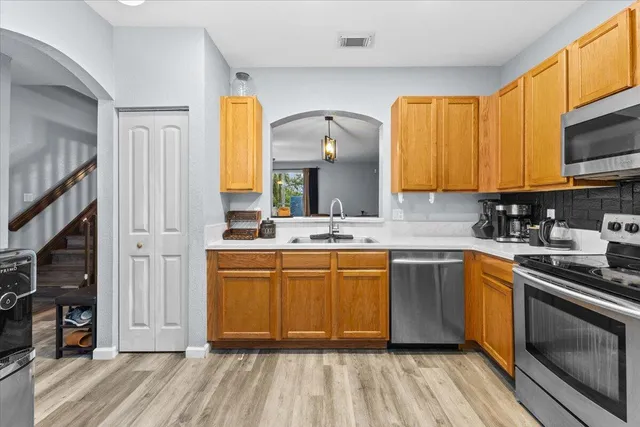 a kitchen with stainless steel appliances granite countertop a stove a sink and a microwave