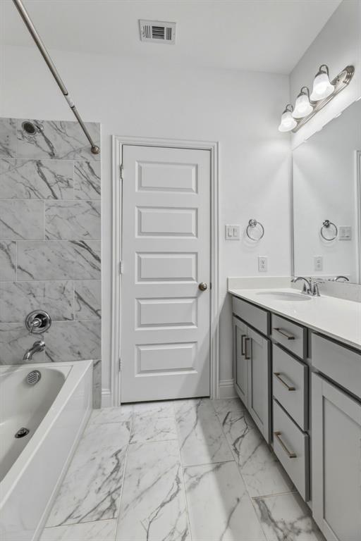3120 Stonelake Ridge Lewisville, TX 75010 - Photo 33 of 40 a bathroom with a sink a mirror and a bathtub