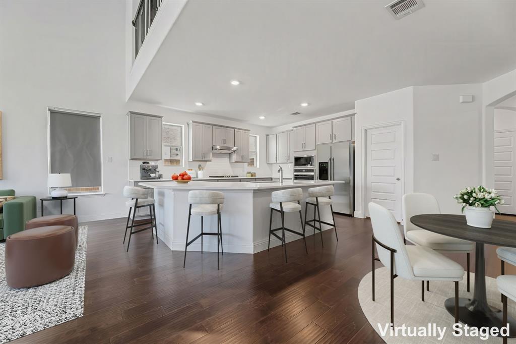 3120 Stonelake Ridge Lewisville, TX 75010 - Photo 7 of 40 a living room with stainless steel appliances kitchen island granite countertop furniture and a dining table with wooden floor