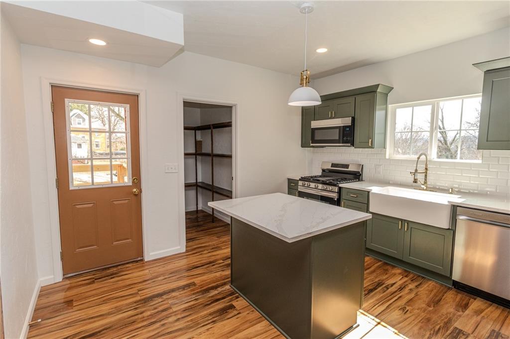 325 Laughlin Street Dawson, PA 15428 - Photo 13 of 34 a kitchen with kitchen island a sink dishwasher a stove and a refrigerator with wooden floor