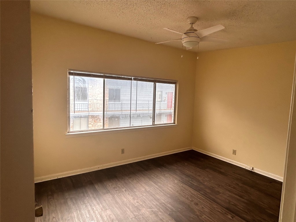 2408 Longview Street, Unit 202 Austin, TX 78705 - Photo 2 of 11 Spare room with plenty of natural light, dark wood-style flooring, a textured ceiling, and a ceiling fan