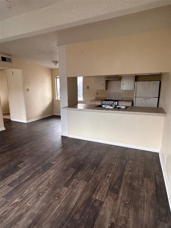 2408 Longview Street, Unit 202 Austin, TX 78705 - Photo 11 of 11 Kitchen featuring freestanding refrigerator, dark wood-type flooring, open floor plan, a peninsula, and under cabinet range hood