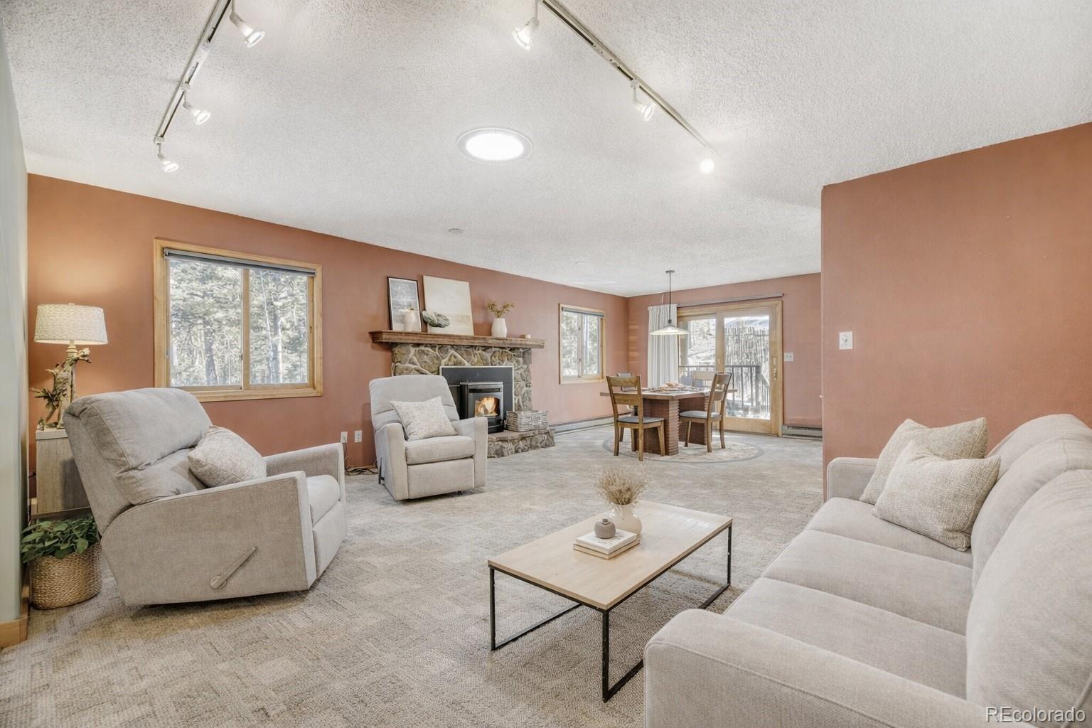 26196 Rea Avenue Conifer, CO 80433 - Photo 11 of 46 a living room with furniture and a fireplace