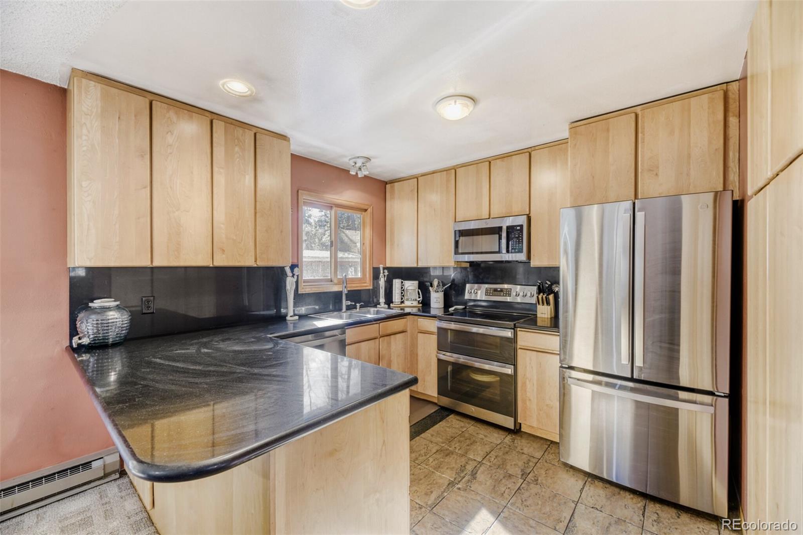 26196 Rea Avenue Conifer, CO 80433 - Photo 13 of 46 a kitchen with stainless steel appliances granite countertop a refrigerator a stove a sink and a microwave