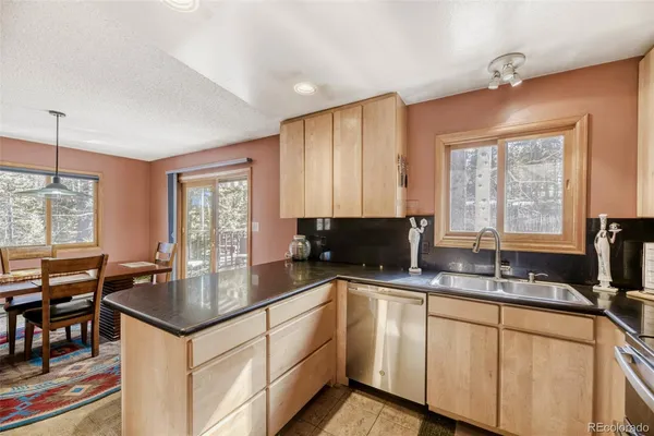 a kitchen with stainless steel appliances granite countertop a sink a stove and cabinets