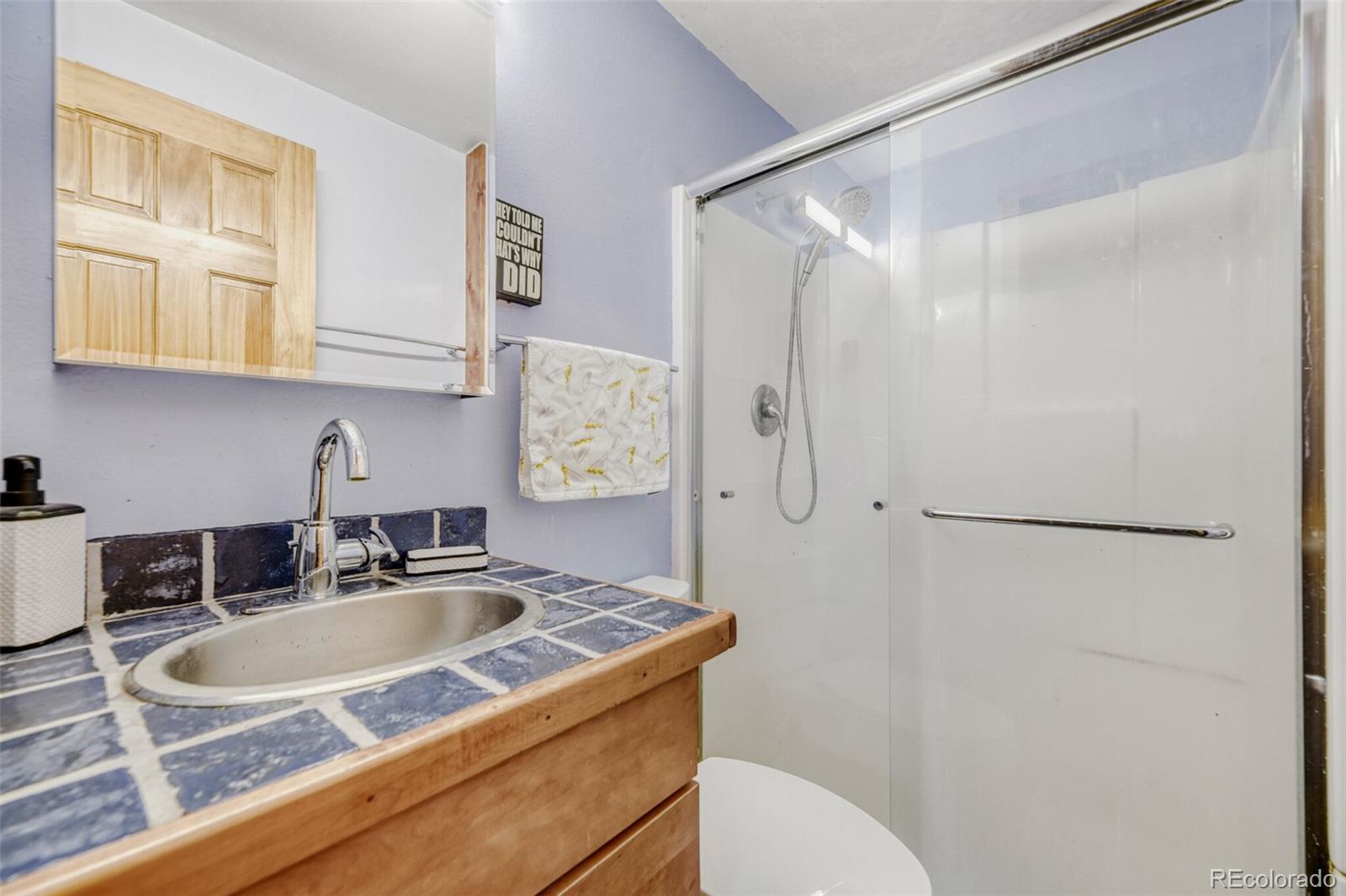 26196 Rea Avenue Conifer, CO 80433 - Photo 19 of 46 a bathroom with a sink and mirror