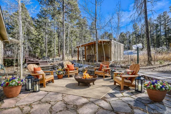 a view of a patio with couches and chairs under an umbrella