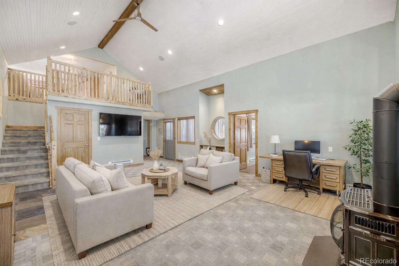 26196 Rea Avenue Conifer, CO 80433 - Photo 3 of 46 a living room with furniture flat screen tv and a fireplace