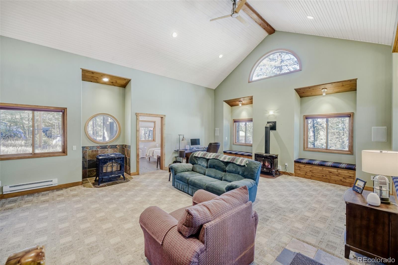 26196 Rea Avenue Conifer, CO 80433 - Photo 39 of 46 a living room with furniture a large window and a fireplace