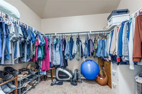 a view of walk in closet with clothes and shoes