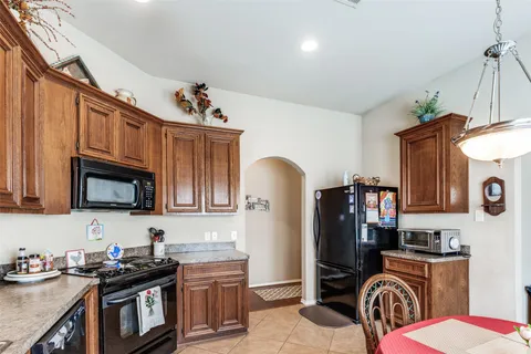 a kitchen with stainless steel appliances granite countertop a stove top oven a sink dishwasher and cabinets with wooden floor
