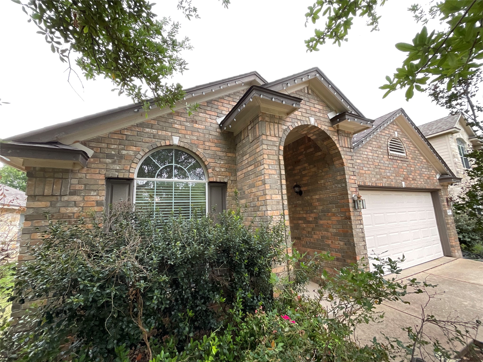 View of front facade with a garage, brick siding, and concrete driveway