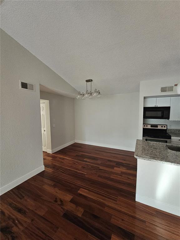 5132 Conroy Road, Unit 937 Orlando, FL 32811 - Photo 3 of 6 a view of kitchen and empty room with wooden floor
