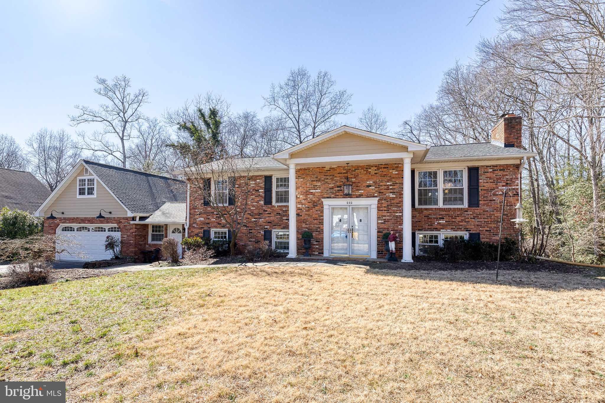 a front view of a house with a yard covered in snow