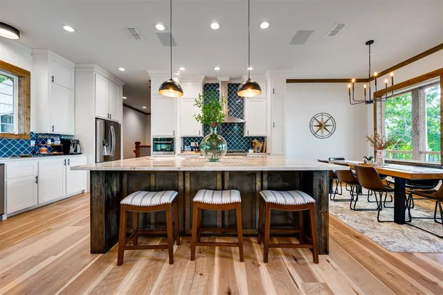 a kitchen with granite countertop a table and chairs in it
