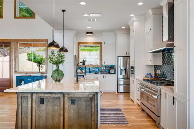 a kitchen with stainless steel appliances granite countertop a stove a refrigerator and a wooden cabinets