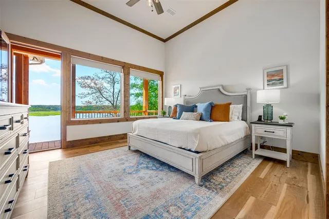 a bedroom with a bed lamp and a large window