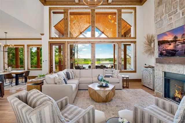 a living room with furniture a fireplace and a floor to ceiling window