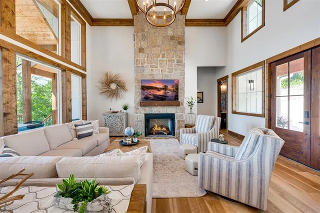 a living room with furniture a fireplace and floor to ceiling windows
