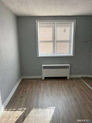a view of a room with wooden floor and window