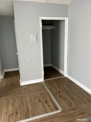 an empty room with wooden floor & cabinet