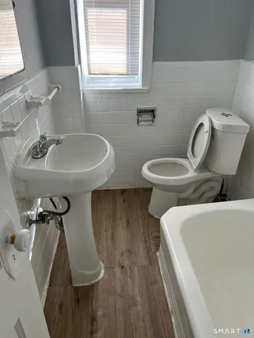 a bathroom with a sink mirror bathtub and toilet