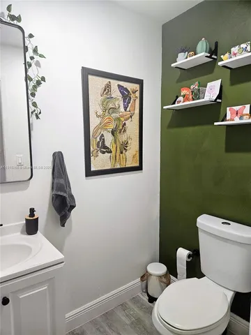 a bathroom with a toilet sink and mirror